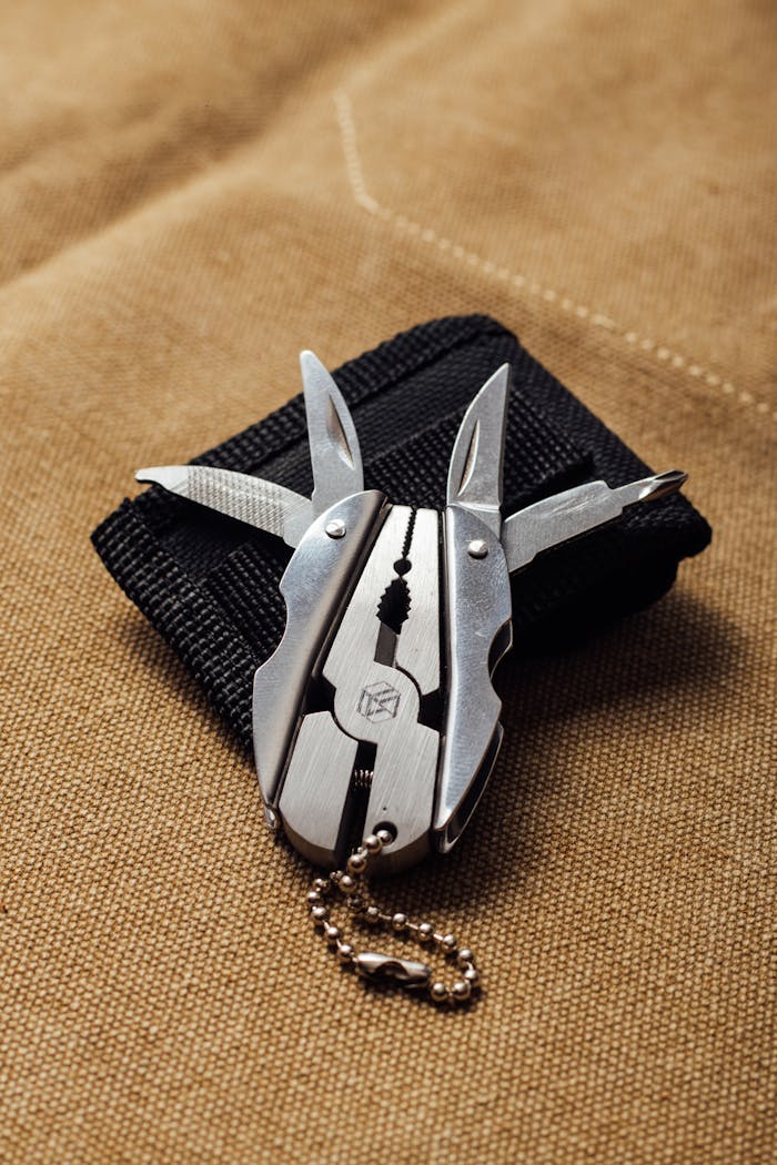 Multifunctional tool on a black pouch with canvas background.